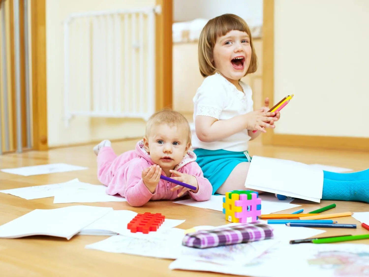 Two young children drawing at a classroom table